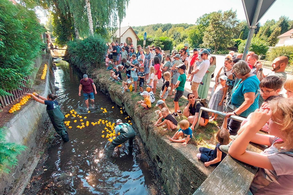 Die Besucherinnen und Besucher des Festes beobachten den Ziel­einlauf der Rennenten am Heiligenhäuschen.