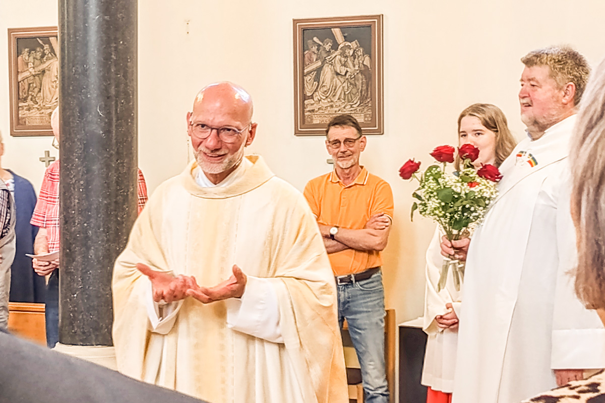 So kennen wir ihn unseren Pfarrer Roland Baule, rechts daneben Diakon Otto mit Rosen für die Helfer.
