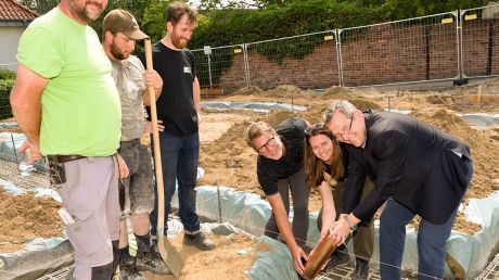 Matthias Kaufmann, Carolin Bettels und René Marienfeldt (von rechts) beim Einlegen der kupfernen Dokumentenhülse in den Beton des Fundamentes.