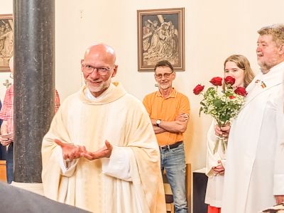 So kennen wir ihn unseren Pfarrer Roland Baule, rechts daneben Diakon Otto mit Rosen für die Helfer.