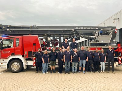Kameradinnen und Kameraden der Freiwilligen Feuerwehr Bettrum vor der Teleskopmastbühne der  Werkfeuerwehr Volkswagen AG Wolfsburg.