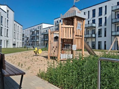 Grünfläche und Spielplatz im Innenhof bieten Schutz vor Lärm und Verkehr.